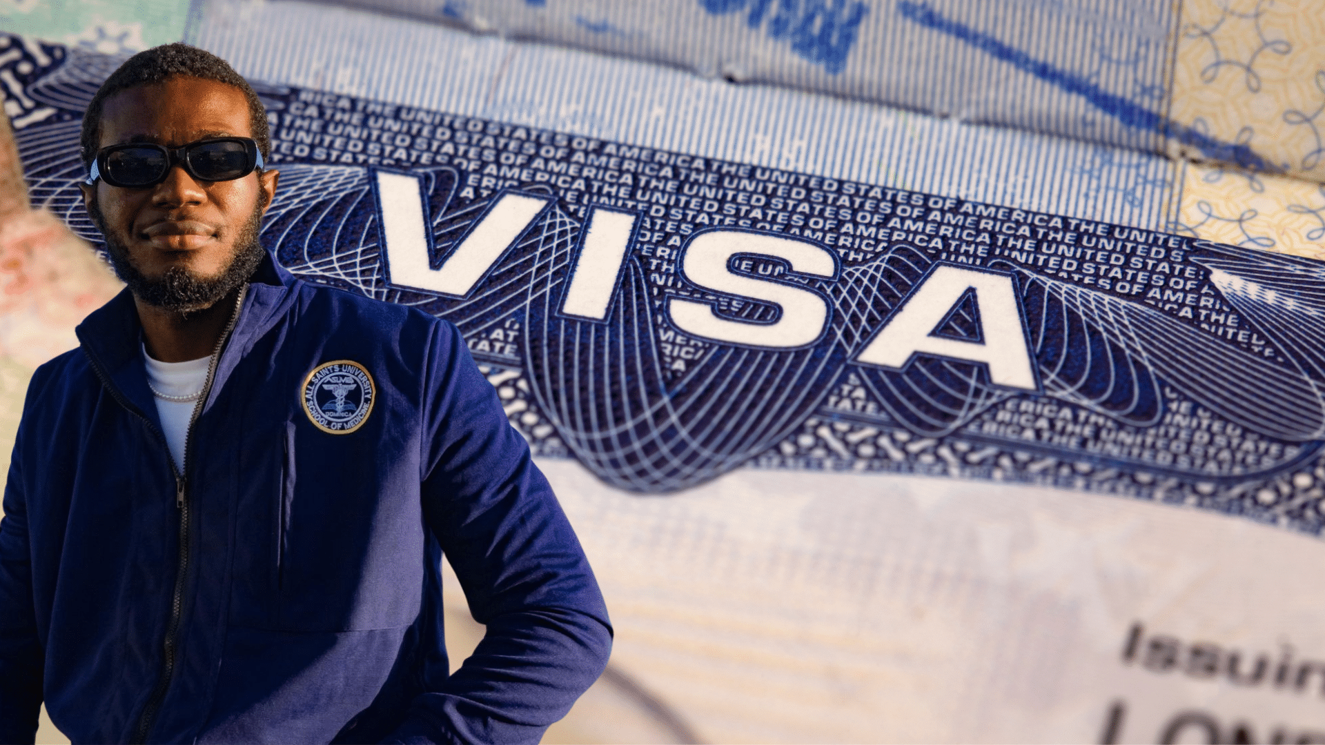 The image shows a person wearing a navy-blue jacket with the All Saints University School of Medicine logo on the left side. The background features a close-up of a U.S. visa document with the word "VISA" prominently displayed in white letters, along with the repeated text "UNITED STATES OF AMERICA" in a patterned design. This likely signifies a student or graduate from All Saints University securing a visa, possibly related to their 2025 residency appointments in the U.S.